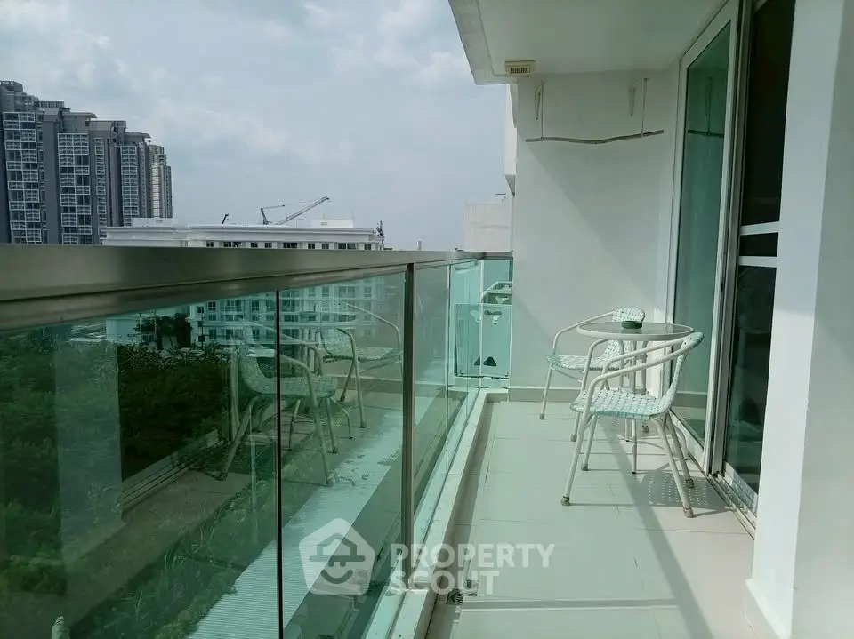 Spacious balcony with glass railing offering city views in modern apartment