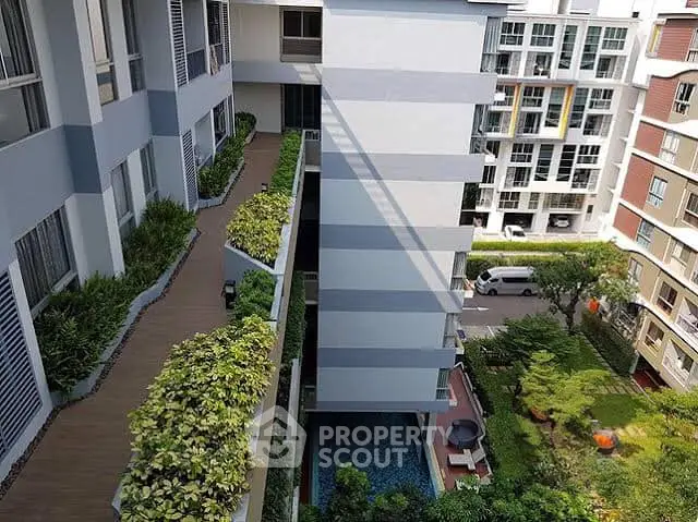 Modern apartment building with lush greenery and pool view