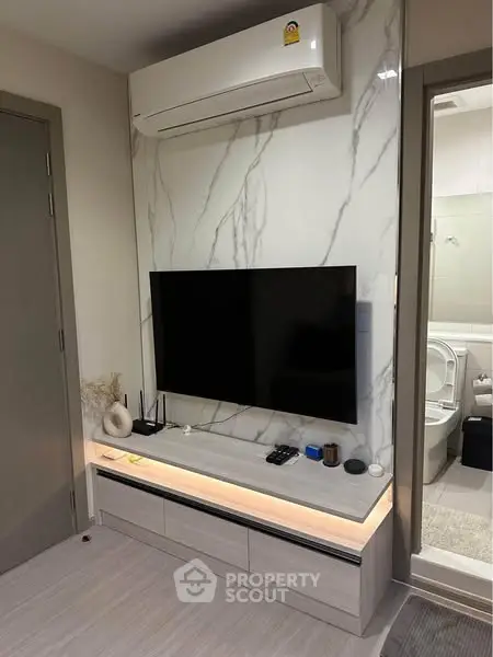 Modern living room with sleek TV setup and air conditioning