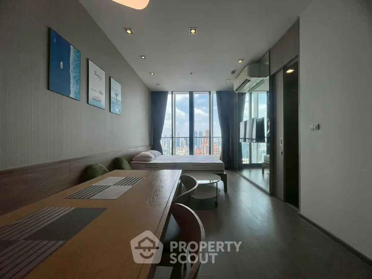 Modern studio apartment with panoramic city view and stylish interior design.