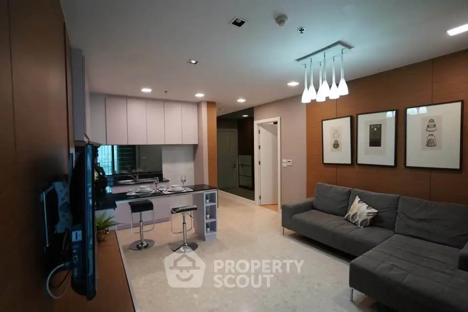 Modern living room with open kitchen, stylish decor, and cozy seating area in a contemporary apartment.