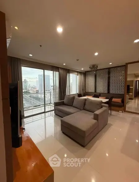 Spacious living room with city view and modern decor in high-rise apartment.