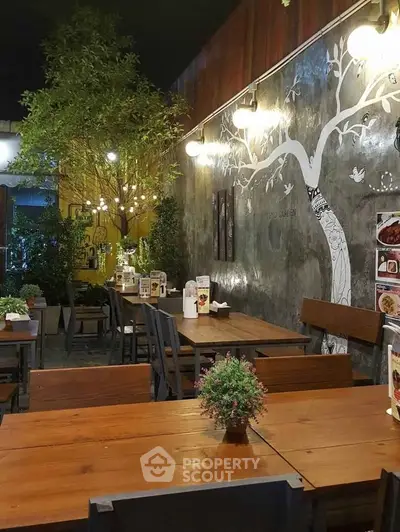 Charming restaurant interior with wooden tables, wall art, and ambient lighting for a cozy dining experience.