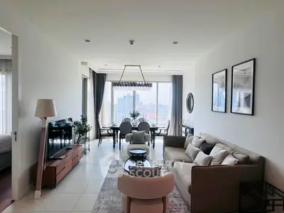 Spacious modern living room with city view, elegant decor, and ample natural light.
