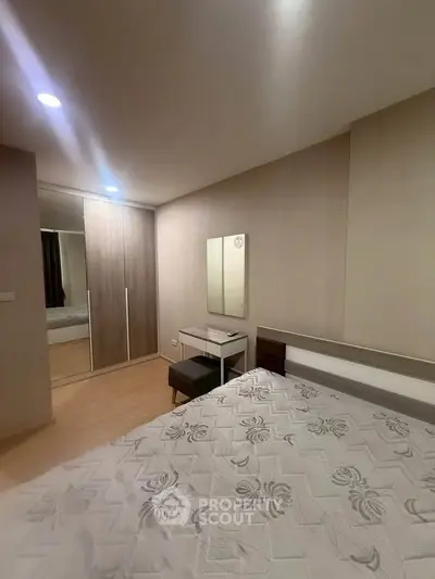 Modern bedroom with stylish decor and ample storage space in a contemporary apartment.