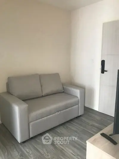 Cozy living room with modern gray sofa and sleek wooden flooring