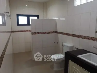 Spacious modern bathroom with elegant tile design and natural light.