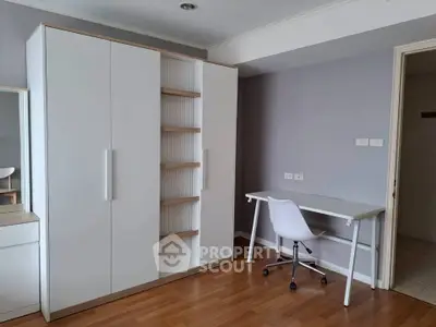 Modern study room with sleek white furniture and wooden flooring