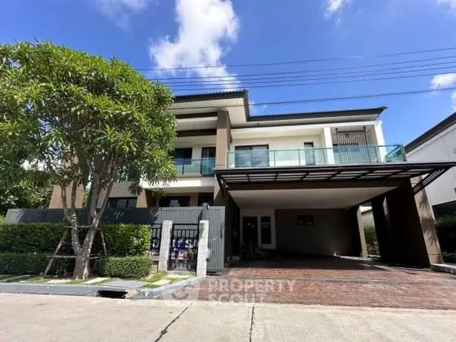 Modern two-story house with spacious driveway and lush greenery