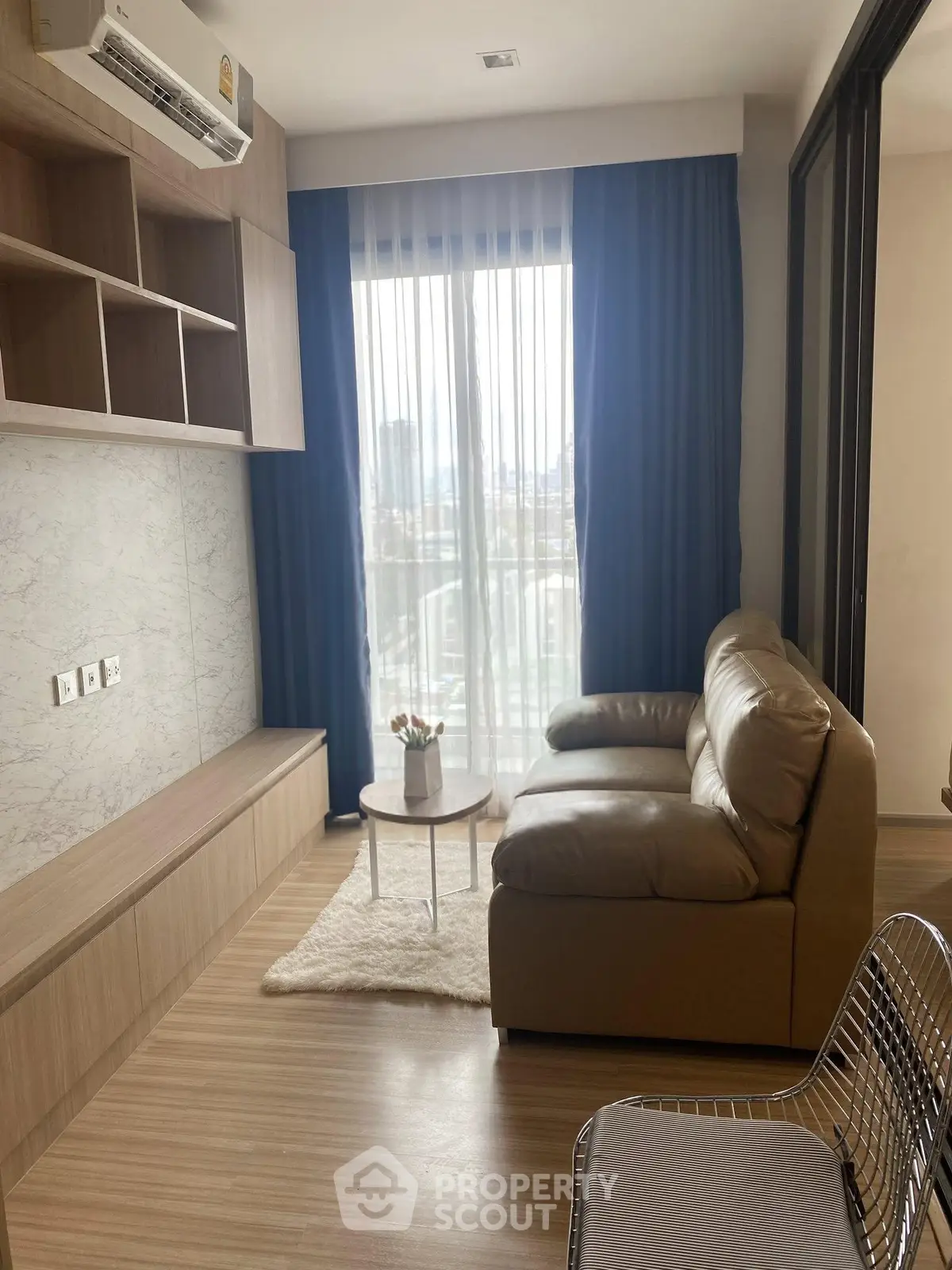 Modern living room with cozy sofa and large window offering city view