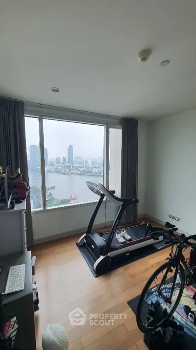 Spacious room with treadmill and city view, perfect for fitness enthusiasts.