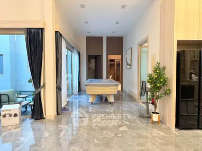 Spacious modern living area with marble flooring and natural light