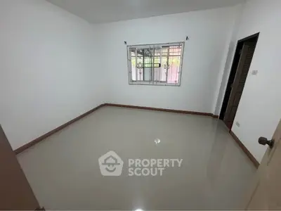 Spacious empty room with glossy tiled floor and window, ideal for customization.
