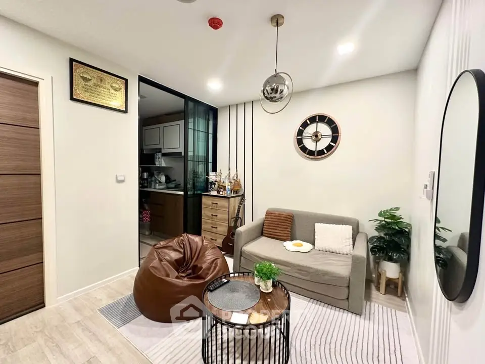 Cozy living room with modern decor and compact kitchen in open layout apartment.