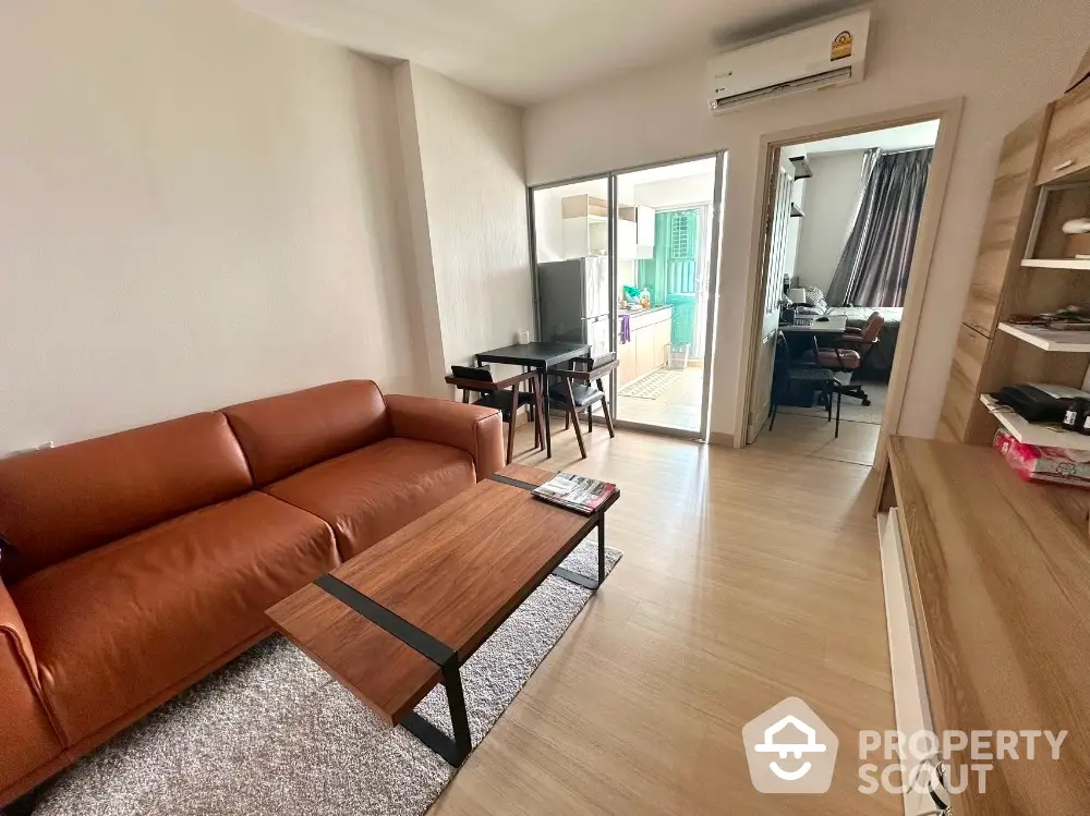 Modern living room with brown leather sofa and wooden coffee table in stylish apartment