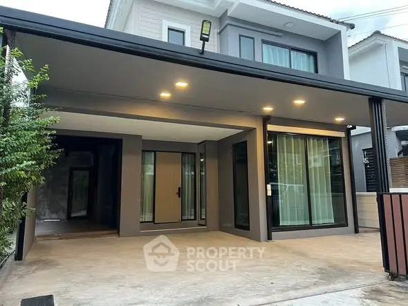 Modern two-story house with spacious carport and sleek exterior design.
