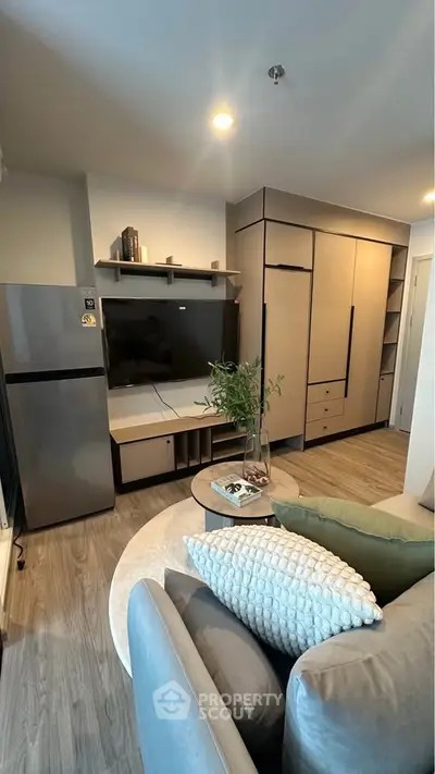Modern living room with sleek furniture and built-in storage, featuring a cozy seating area and stylish decor.