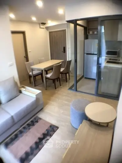 Modern open-plan living room with dining area and kitchen in a cozy apartment.