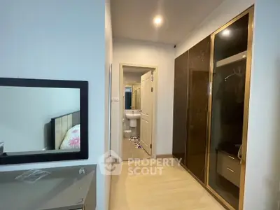 Modern bedroom with sleek wardrobe and view into bathroom