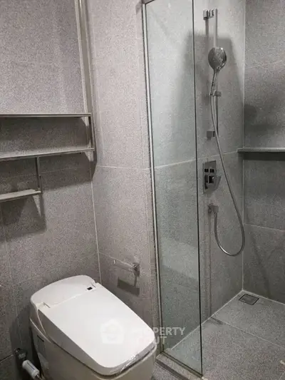 Modern bathroom with sleek shower and toilet in minimalist design.