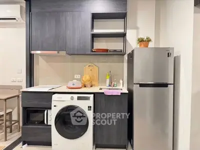 Modern kitchen with sleek appliances and stylish cabinetry in a compact layout.