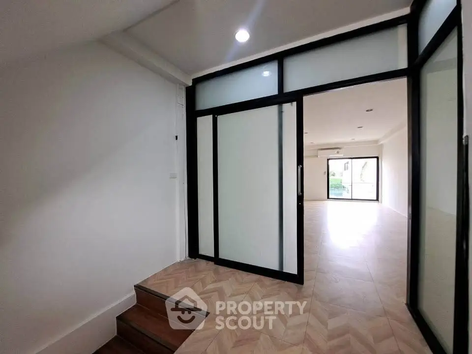 Spacious modern interior with sliding glass doors and wood flooring, perfect for versatile living space.