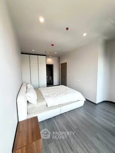 Modern bedroom with sleek design, featuring a cozy bed and ample natural light, perfect for relaxation.