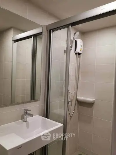 Modern bathroom with sleek shower and stylish sink in a contemporary apartment.