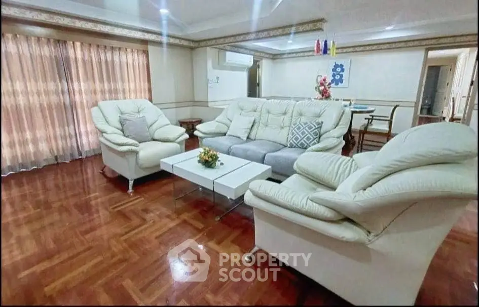 Spacious living room with elegant furniture and wooden flooring, perfect for relaxation and entertainment.