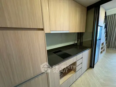 Modern kitchen with sleek cabinetry and induction cooktop in a stylish apartment.