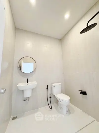 Modern minimalist bathroom with sleek fixtures and rainfall showerhead.