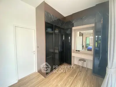 Modern bedroom with sleek black wardrobe and wooden flooring
