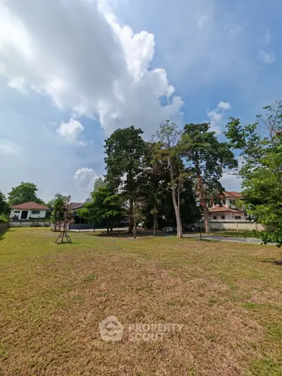 Spacious residential plot with lush greenery and clear blue sky, ideal for building your dream home.
