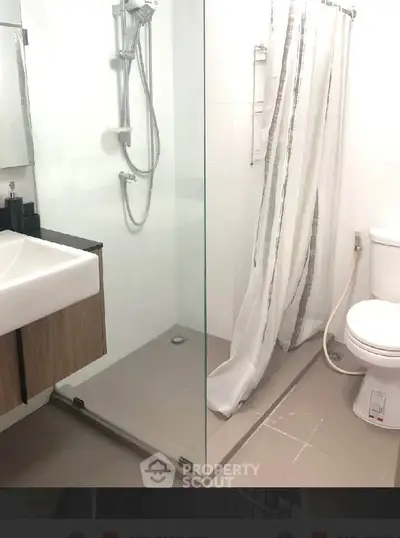 Modern bathroom with glass shower and sleek fixtures in a contemporary apartment.