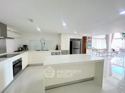 Spacious modern kitchen with island and open layout in bright apartment.