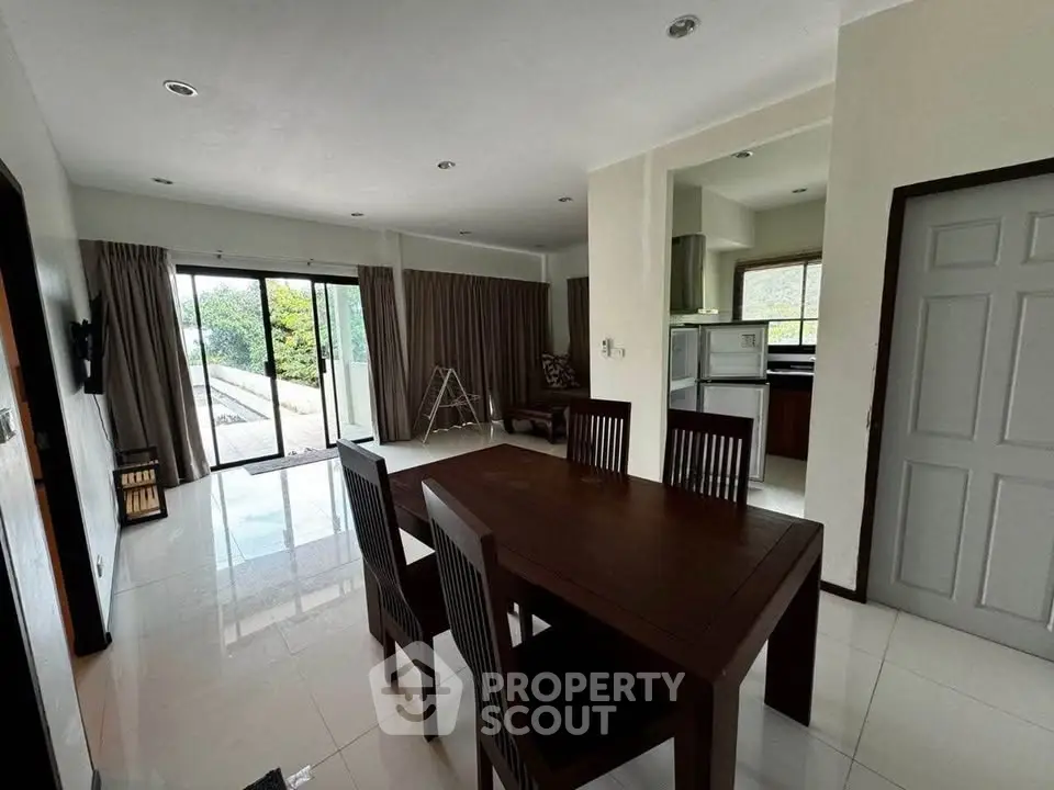 Spacious dining area with modern furniture and natural light in a contemporary home.