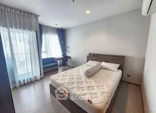 Spacious bedroom with modern decor and large windows for natural light.