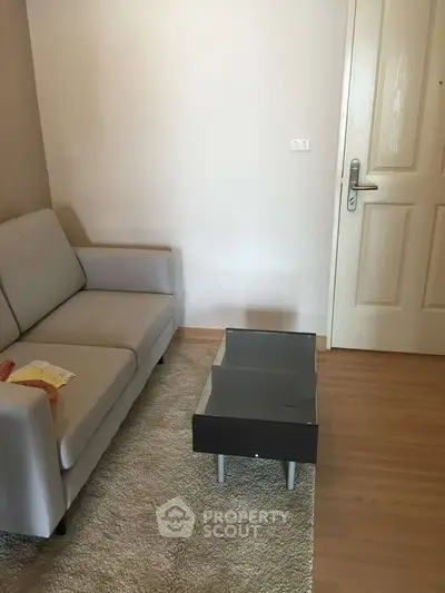 Cozy living room with modern sofa and sleek coffee table on wooden flooring.