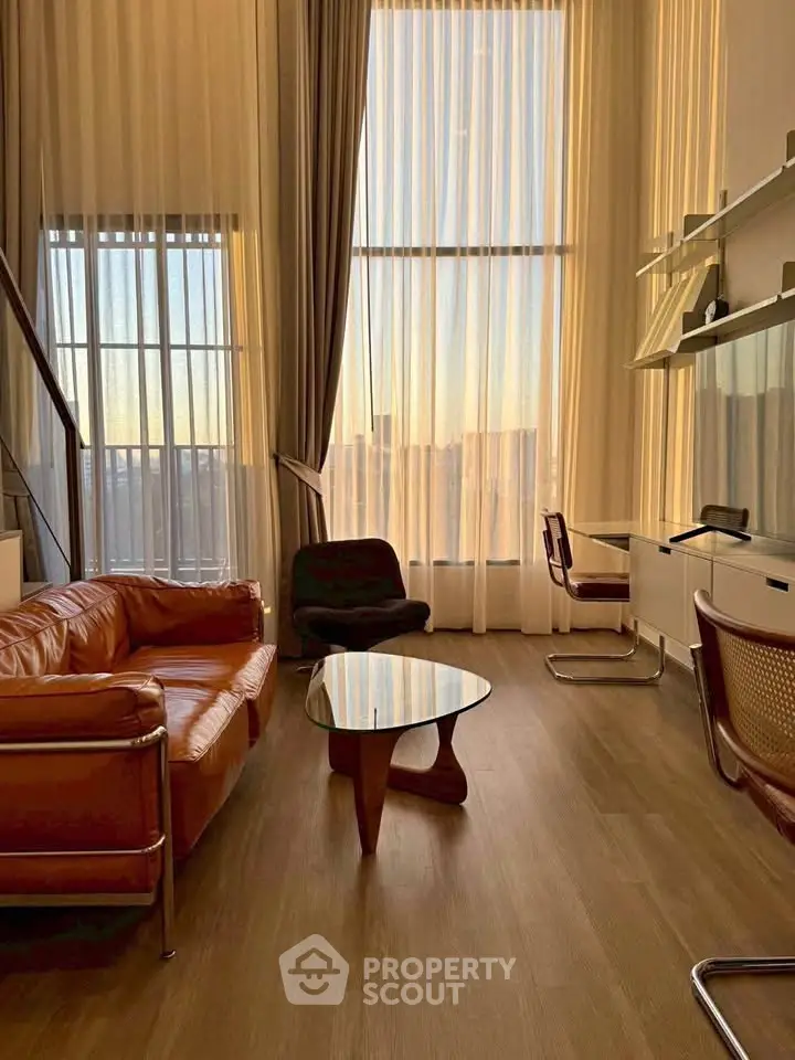 Stunning high-ceiling living room with modern furniture and floor-to-ceiling windows.