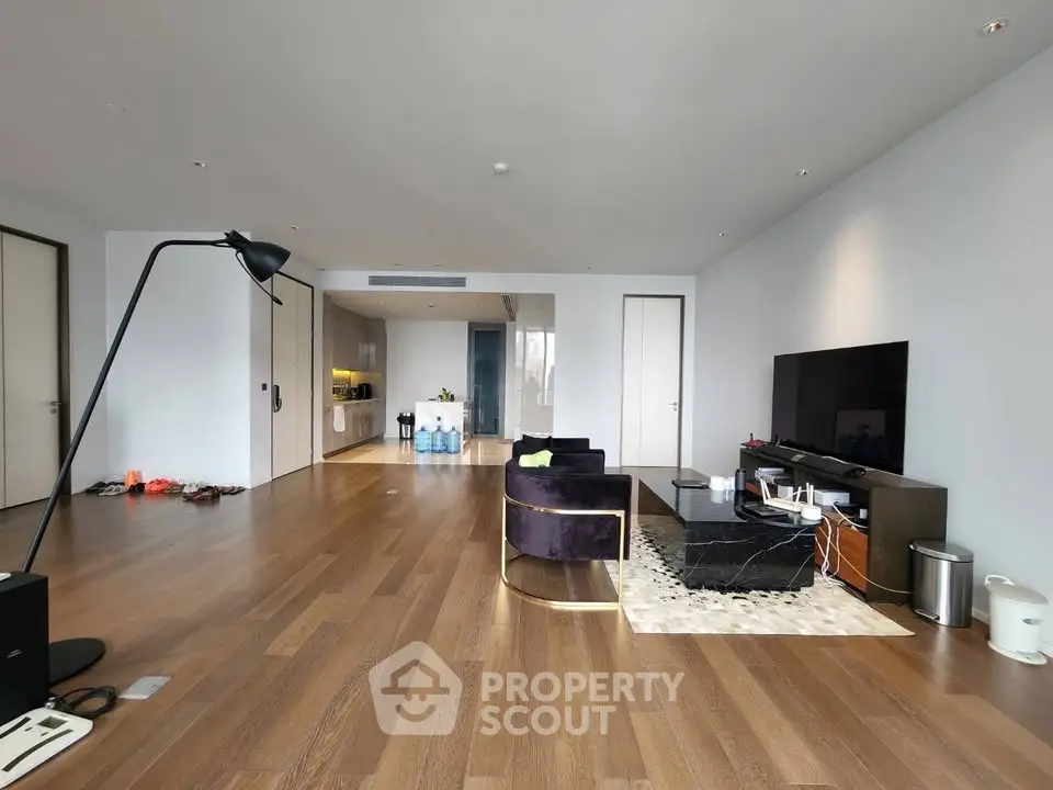 Spacious modern living room with sleek design and open layout, featuring hardwood floors and contemporary furniture.