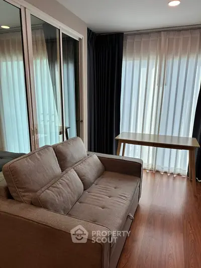 Cozy living room with modern sofa and natural light through large windows