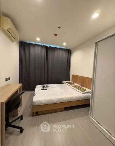 Modern bedroom with sleek design, featuring a comfortable bed, study desk, and ample natural light.