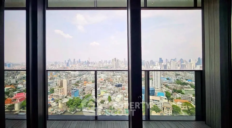 Stunning cityscape view from a high-rise balcony with floor-to-ceiling windows.