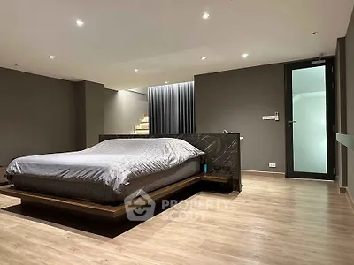 Spacious modern bedroom with sleek design and wooden flooring