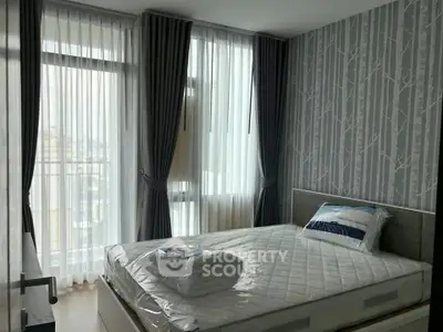 Modern bedroom with large windows and stylish wallpaper in a high-rise apartment.