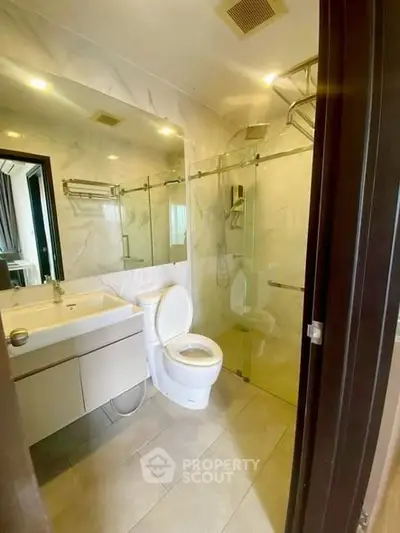 Modern bathroom with glass shower and sleek fixtures in a contemporary home.