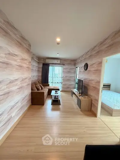 Modern living room with stylish decor and natural light, featuring a cozy sofa and flat-screen TV.