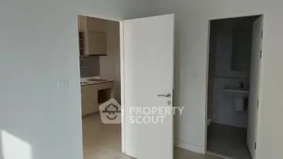 Bright minimalistic interior with open door leading to kitchen and bathroom