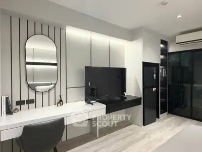 Modern living room with sleek design, featuring a wall-mounted TV and stylish decor.