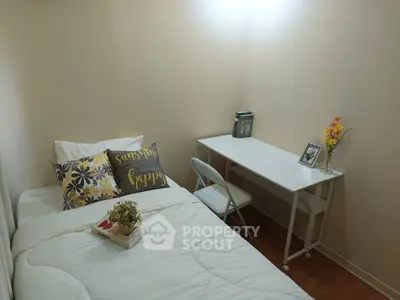 Cozy bedroom with single bed, desk, and decorative accents for a welcoming atmosphere.